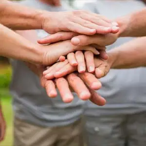 people crossing hands to signify  a group setting