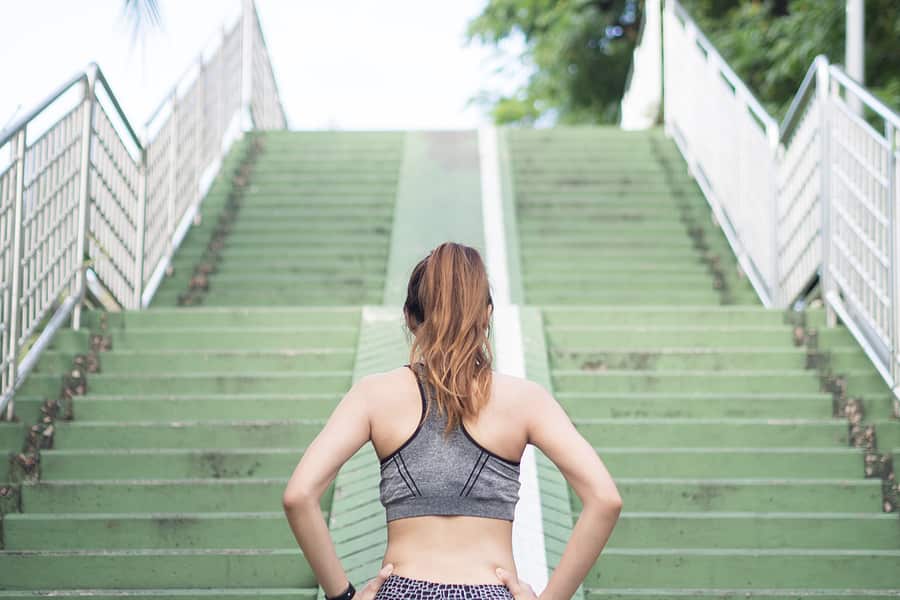 woman in workout clothes getting ready to run up steps
