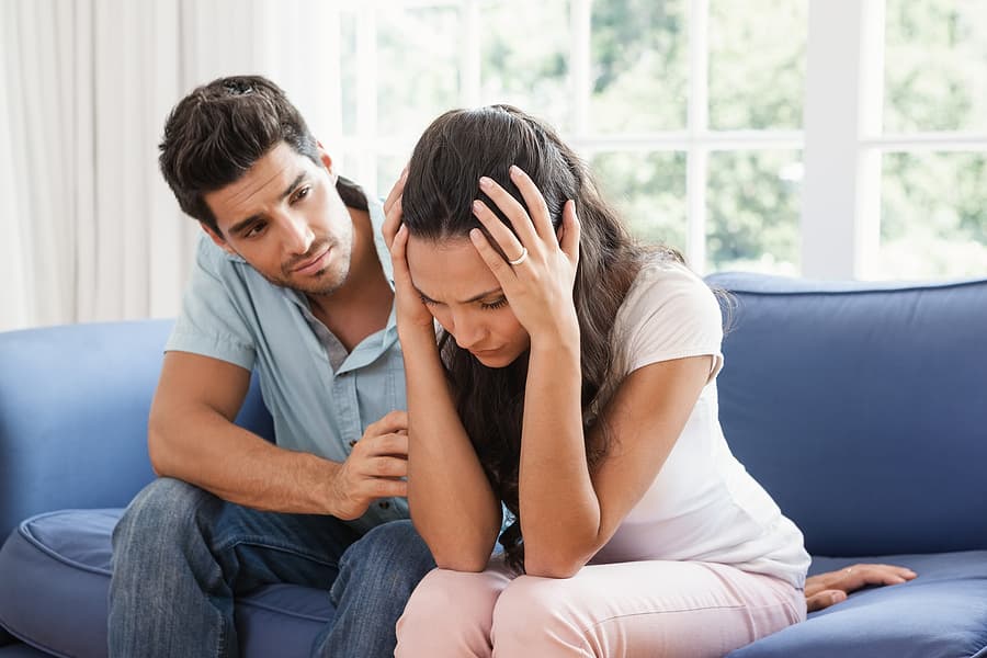 Husband is on the couch with his wife trying to help her heal from his sex addiction.