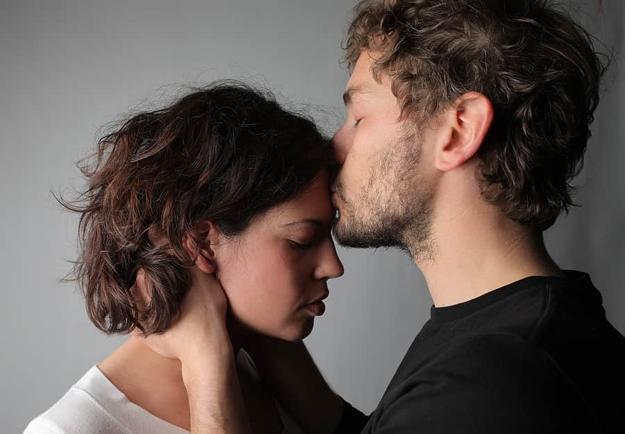 man kissing the forehand of a woman that he is having an emotional affair with